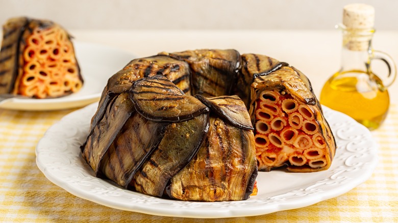 timballo topped with eggplant on white plate