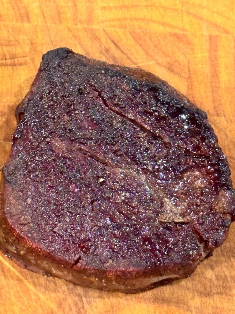 Burnt steak with pink inside.