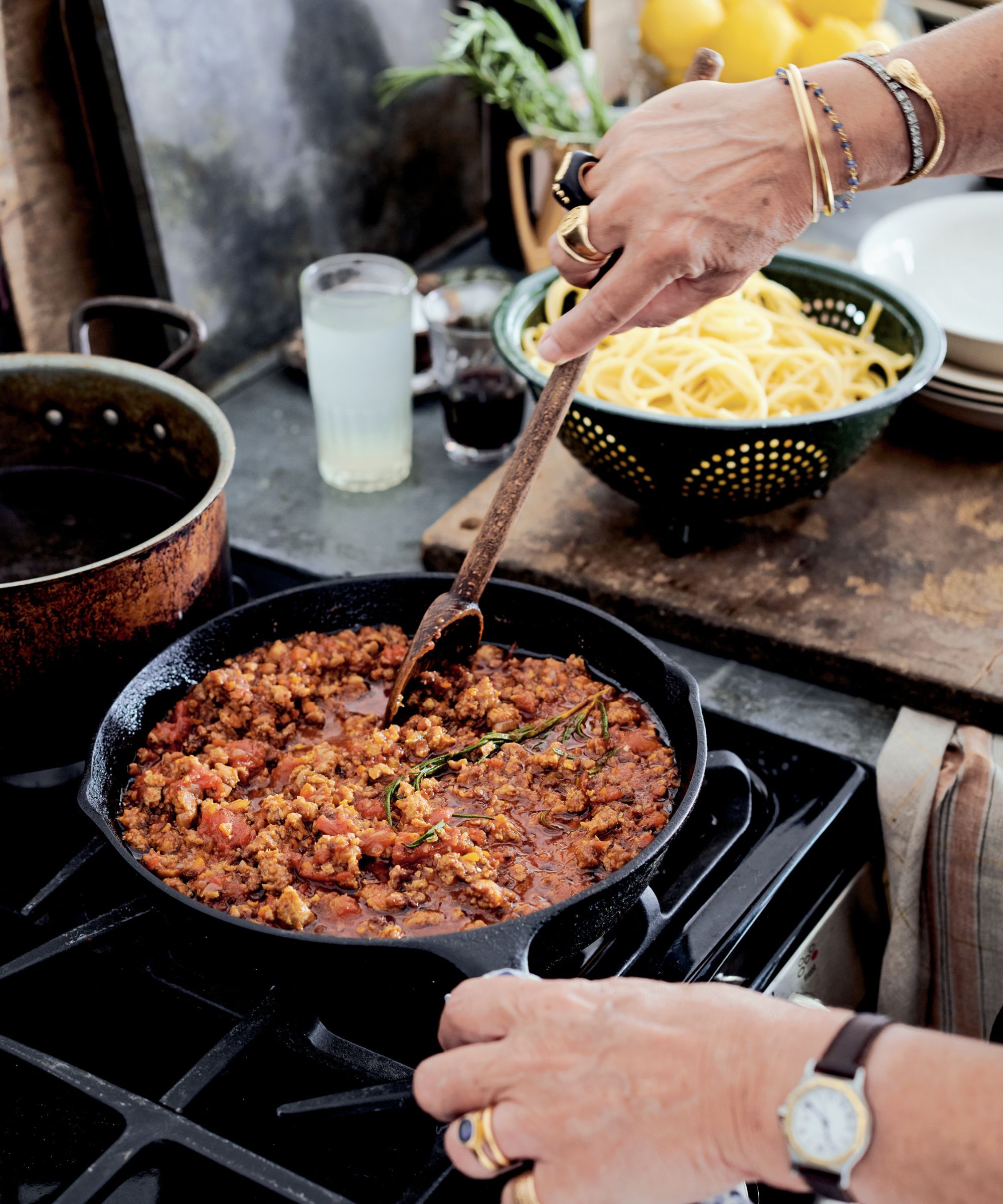 Lucinda Scala Quinn cooking a meat and sauce dish on the stove