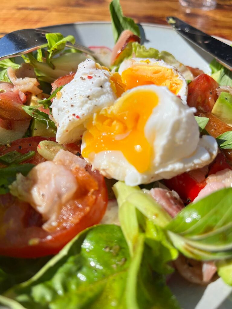 Gooey Poached eggs & Smoked Bacon on home grown Salad with Spice.