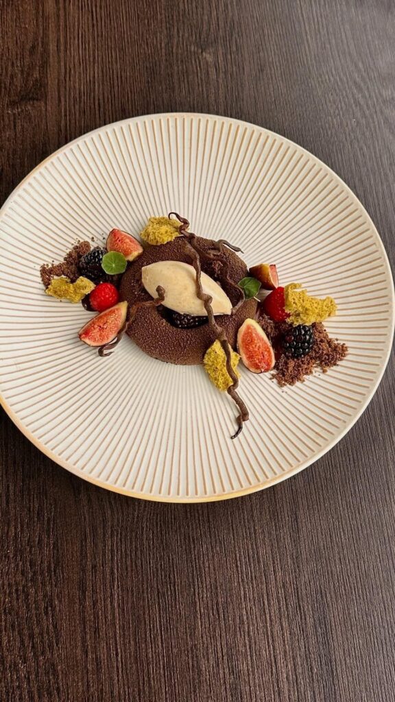 Fig and chocolate cremeux with blackberry jam, hazelnut & fig leaf ice cream, pistachio micro sponge, and chocolate “soil.”