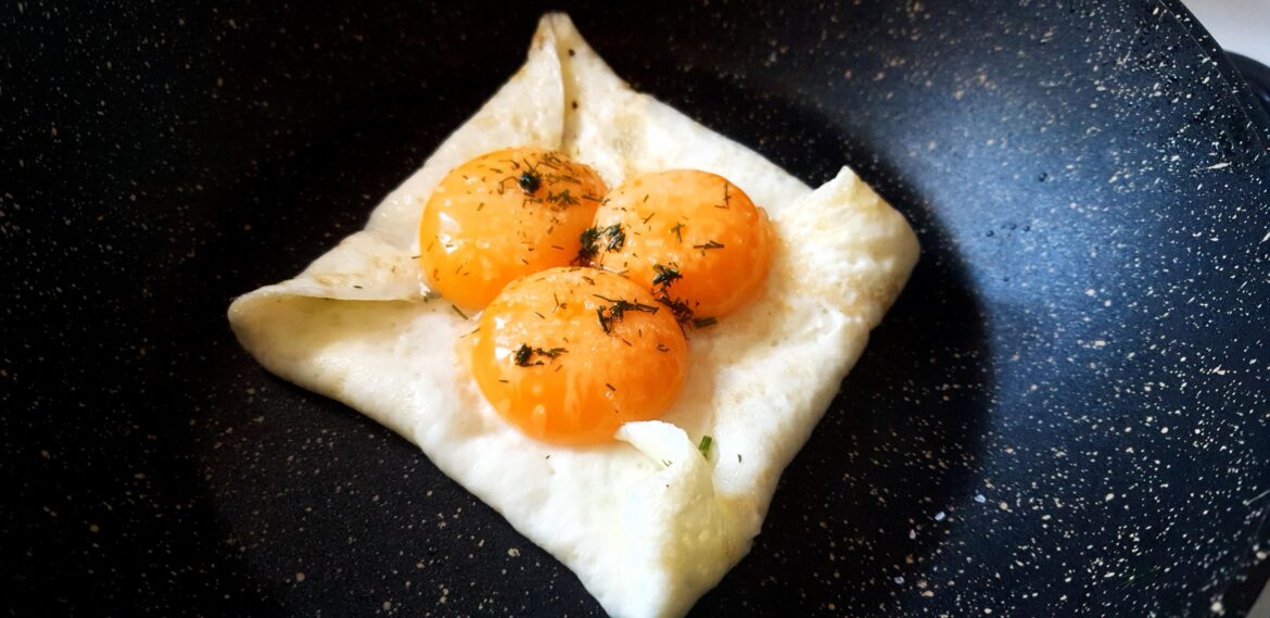 Folded egg whites with yolks on top, sprinkled with salt, pepper and dill