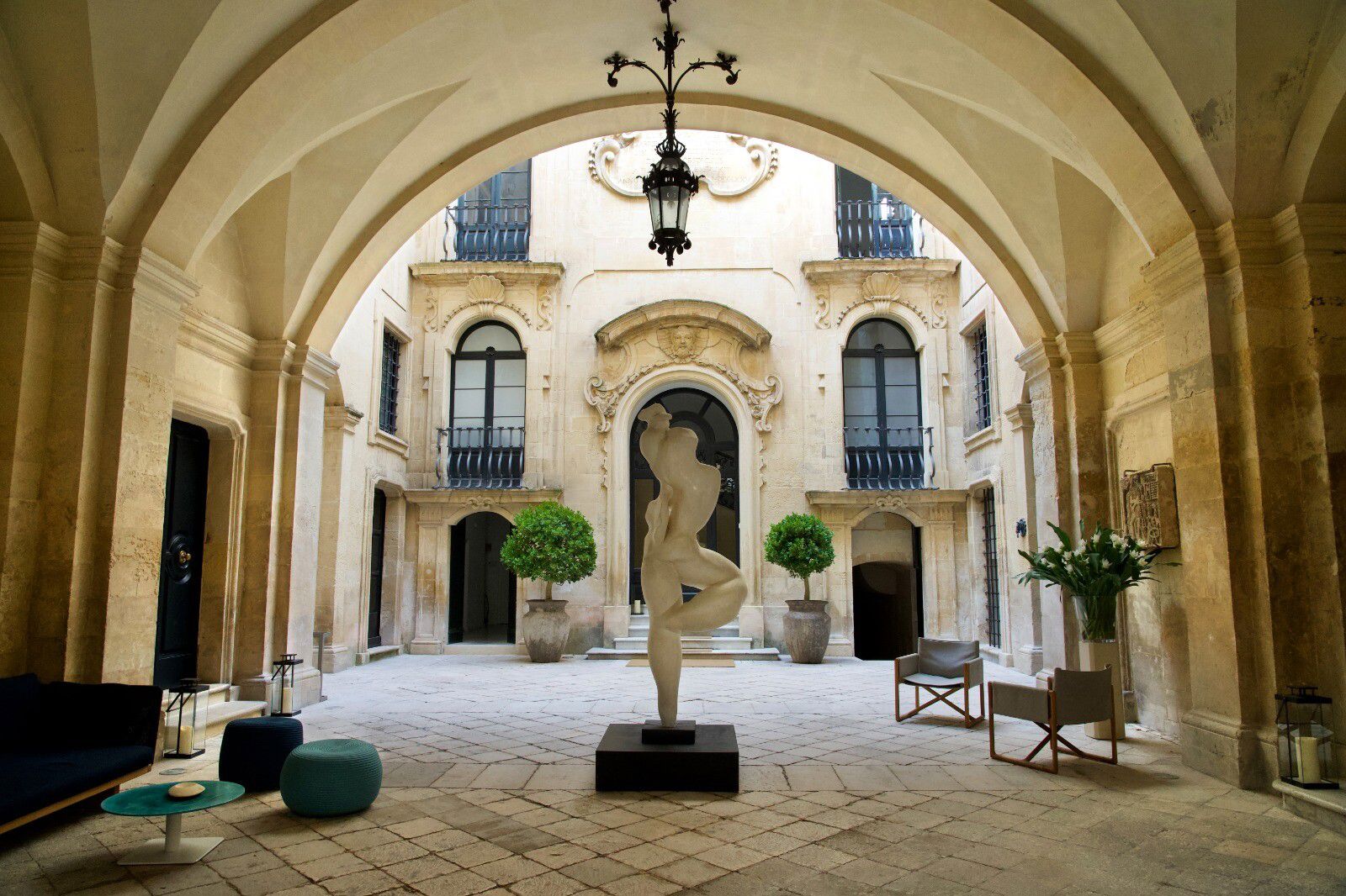 Courtyard with statue and arched walkways.