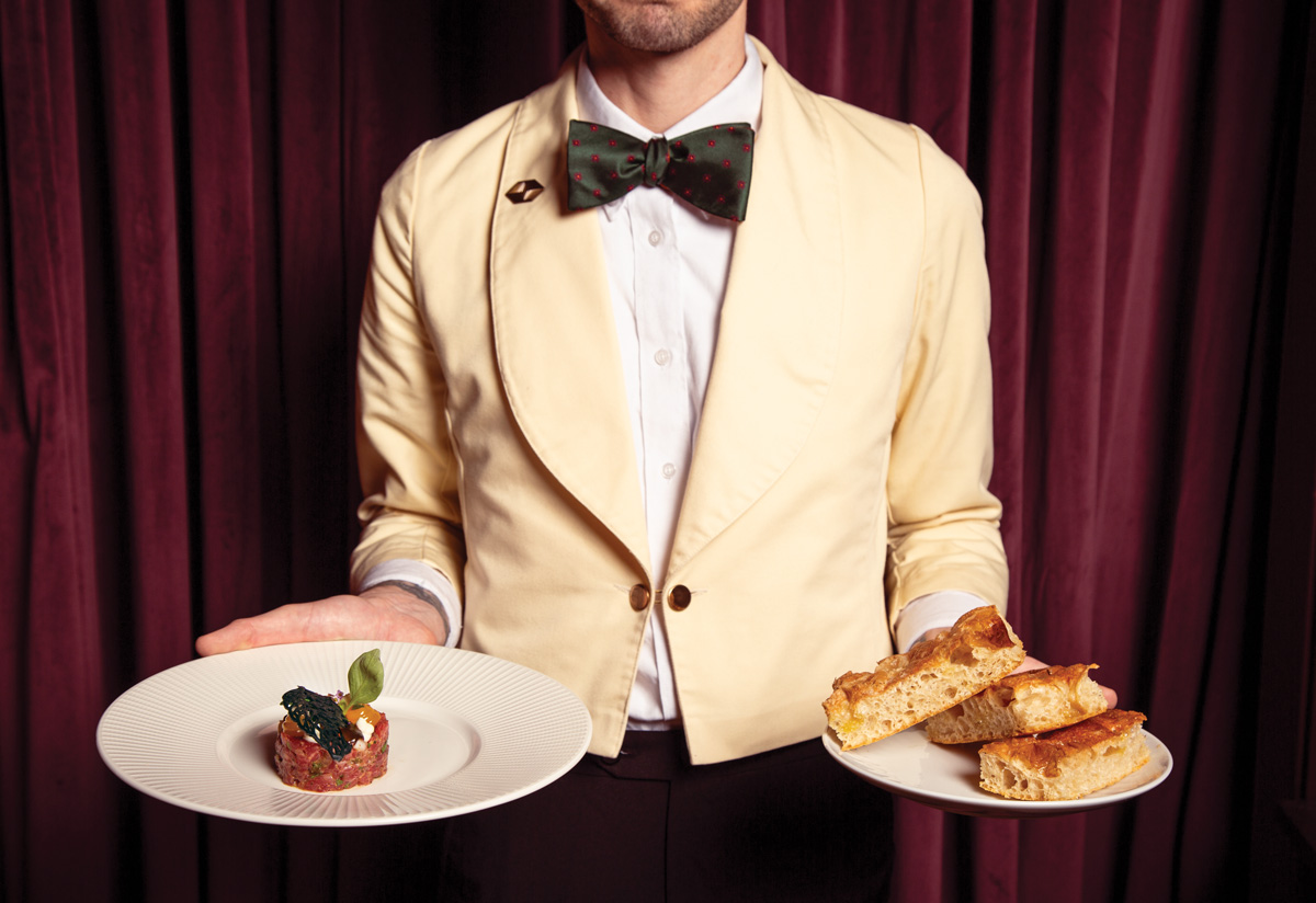 A waiter holding two dishes