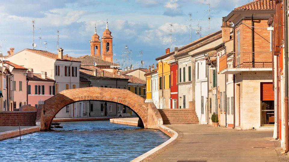 Comacchio (Ferrara, Emilia Romagna, Italy). Canal with bridge and colorful houses.