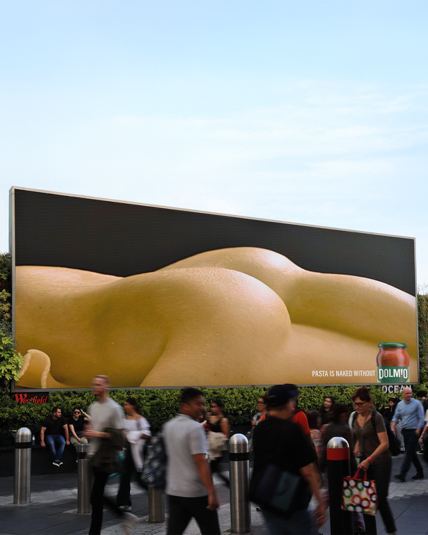 Photo of people walking in front of a billboard