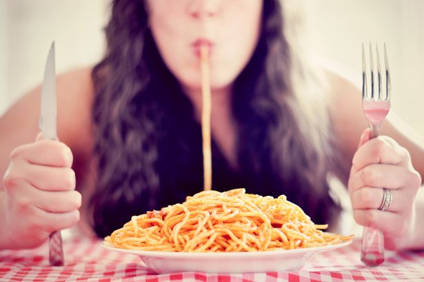 Woman eats bowl of spaghetti
