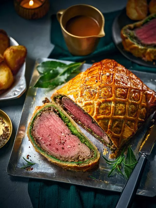 An image of a beef wellington on a dinner spread 