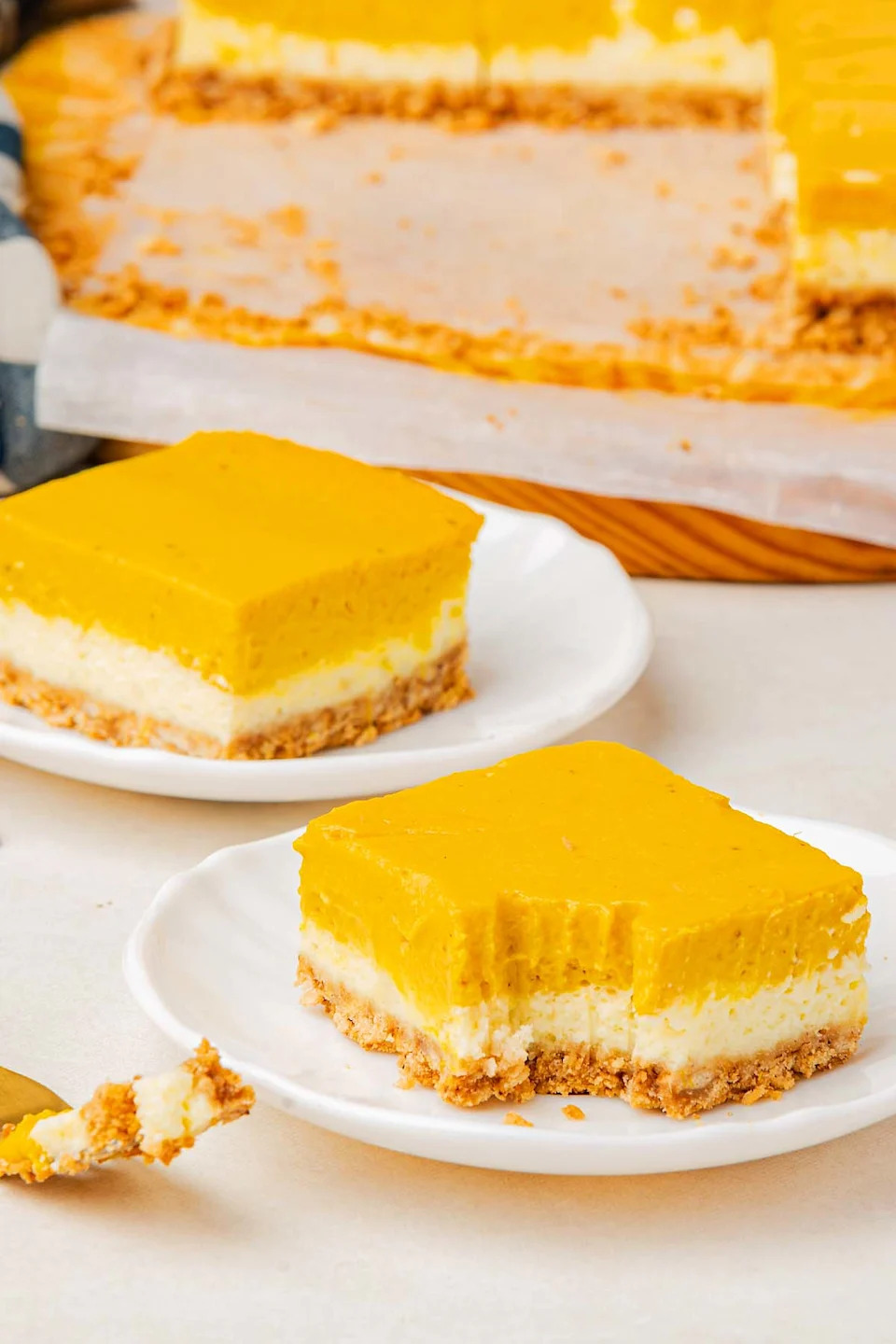 Pumpkin cheesecake bars on a white plate.