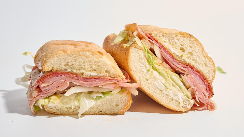 Firehouse Italian sandwich sliced in half on a white table