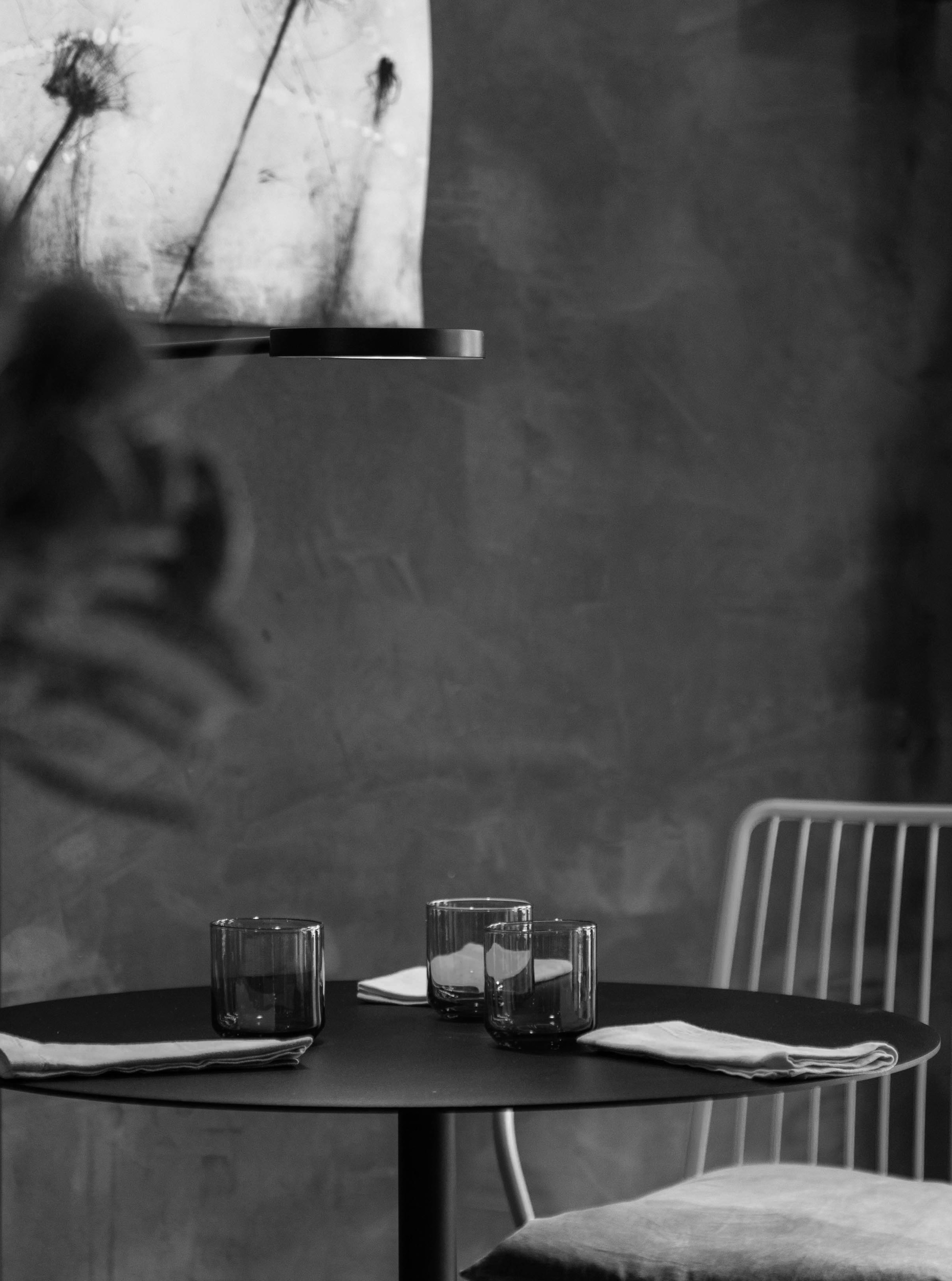 Black and white picture of a minimalist table set with a modern chair and a round table.