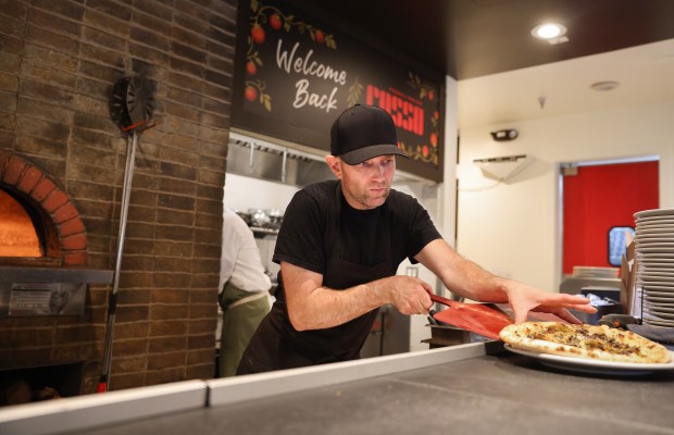 Basu Slade slides a pizza onto a plate at Rosso...