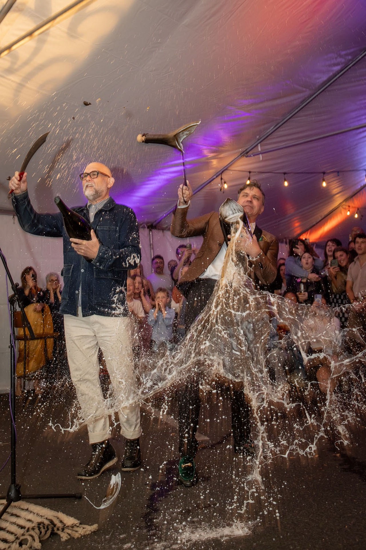 Longtime Nostrana managers Austin Bridges and Nicholas Suher saber bottles of bubbles at Nostrana's 20th anniversary party on Sunday, October 5.