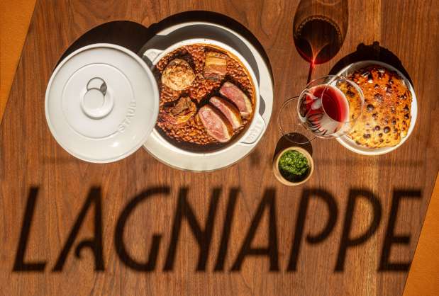 The shadow from a sign in the front window falls upon a table with Cassoulet, duck confit, lamb, red peas at Bistro Lagniappe Thursday, June 19, 2025 in Healdsburg. (John Burgess / The Press Democrat)