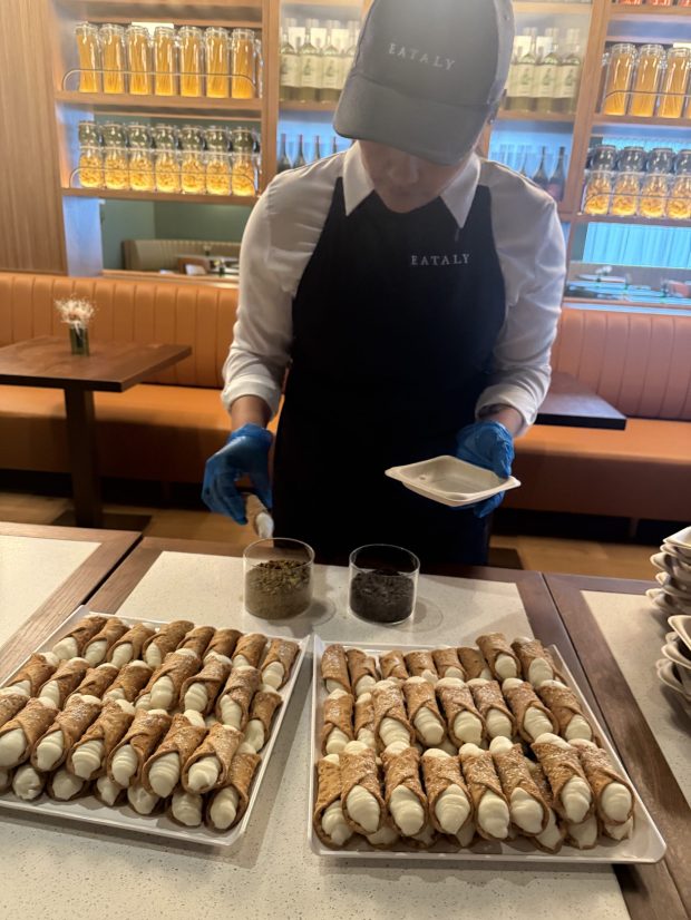 An Eataly team member fills a cannoli at the custom cannoli bar during the grand opening celebration of Eataly at King of Prussia Mall. (PEG DEGRASSA/ DAILY TIMES)
