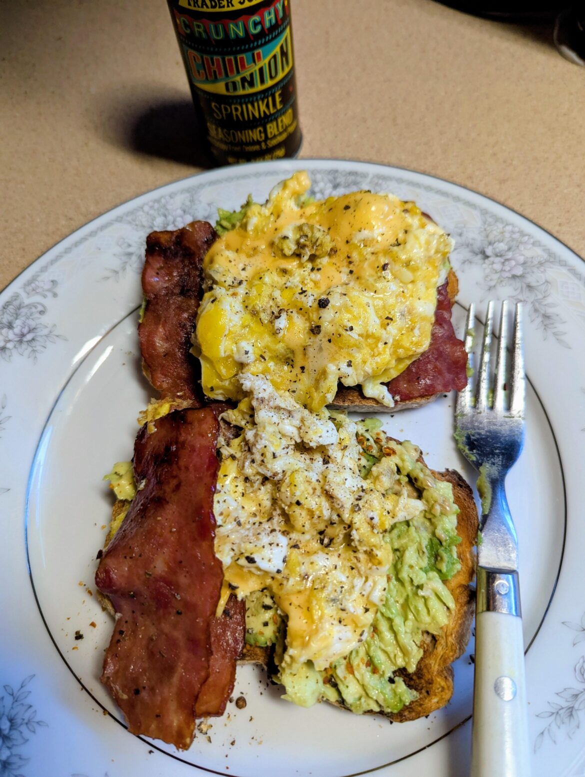 Dirty scrambled cheesy eggs on avocado toast with turkey bacon