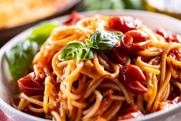 Italian spaghetti pasta with tomato sauce, parmesan and basil - Close up