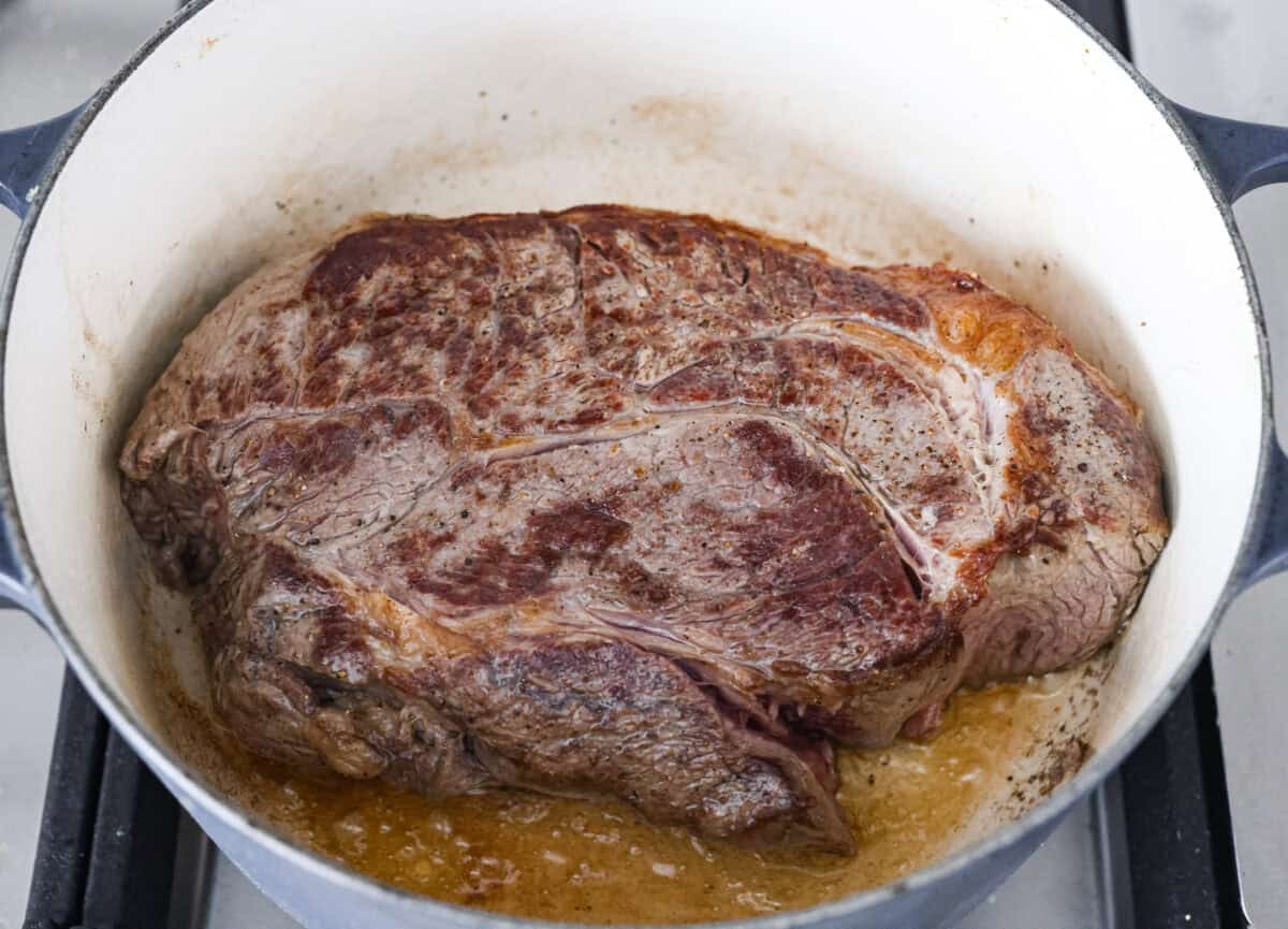 This French Onion Pot Roast is pure comfort food! Slow-cooked to perfection, the roast becomes melt-in-your-mouth tender as it simmers in a rich, savory gravy infused with the deep, caramelized flavor of onions. Roast searing in the dutch oven.