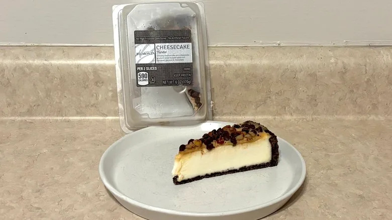 Turtle cheesecake in container and on plate on a neutral background.