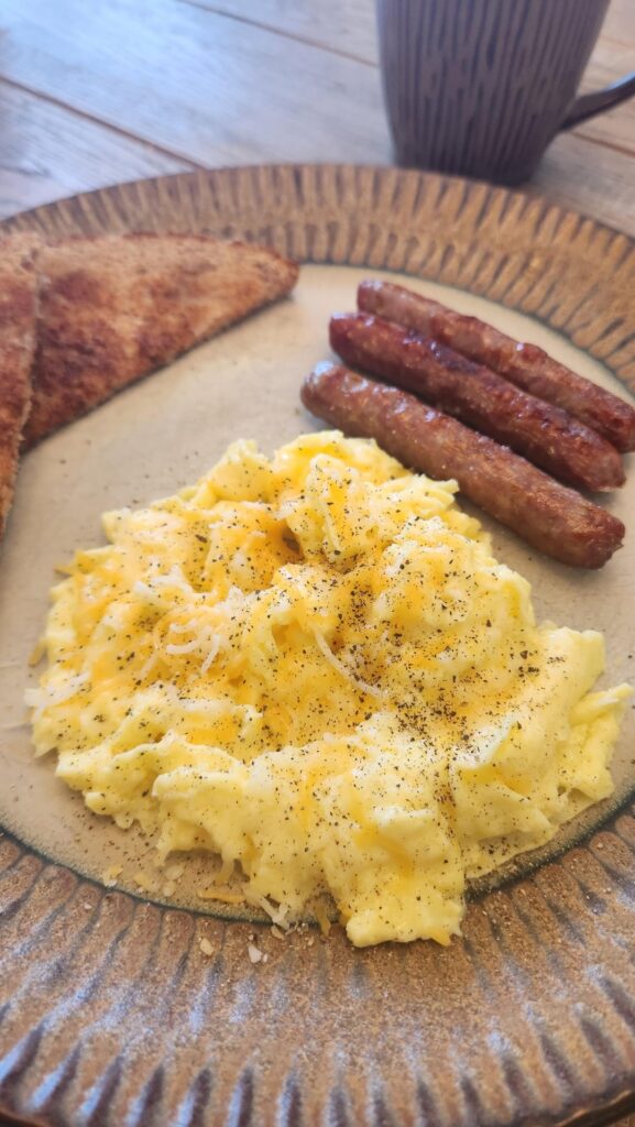 Scrambled eggs, sausage and whole wheat toast with butter