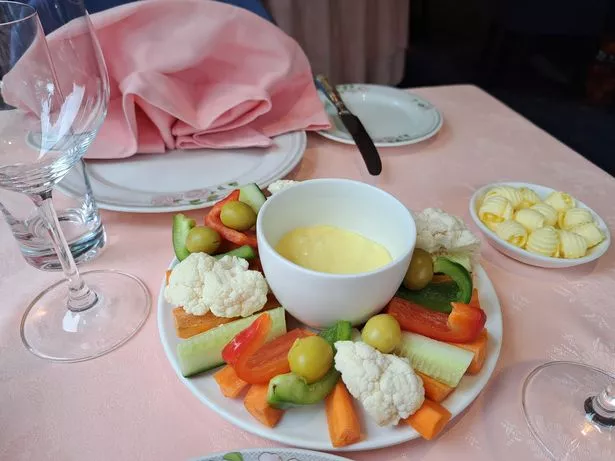 Hors d'oeuvres feature garlic butter with red and green peppers, olives, cucumber and cauliflower