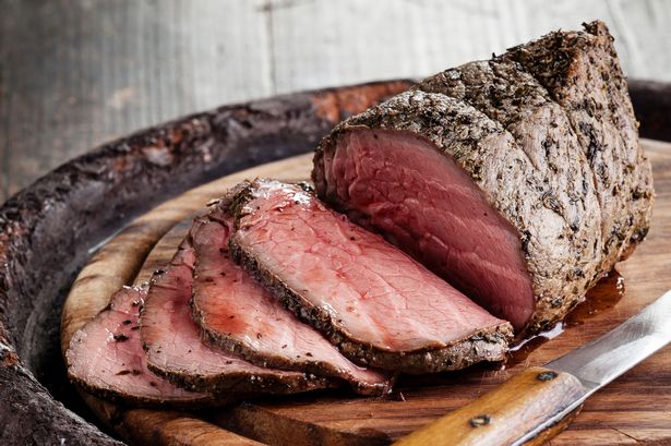 Roast beef on cutting board and knife