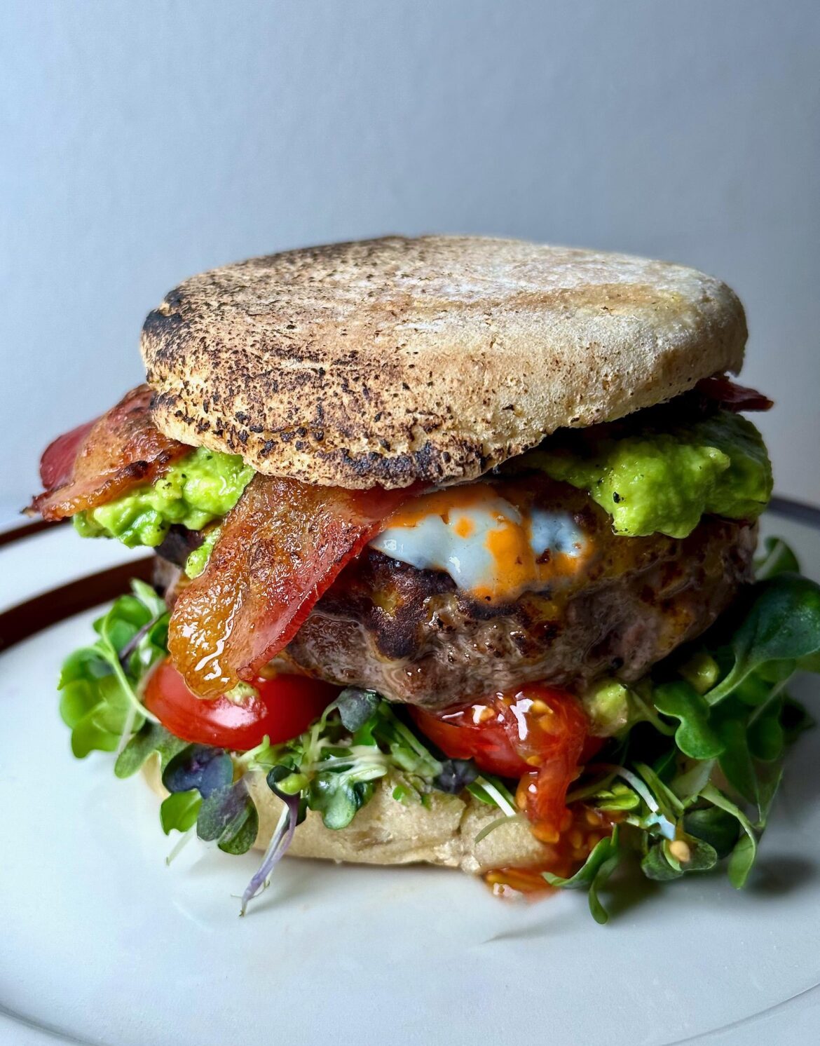 6oz home-ground patty, bacon, homemade guac, Colby Jack, tomatoes, micro greens, English muffin.