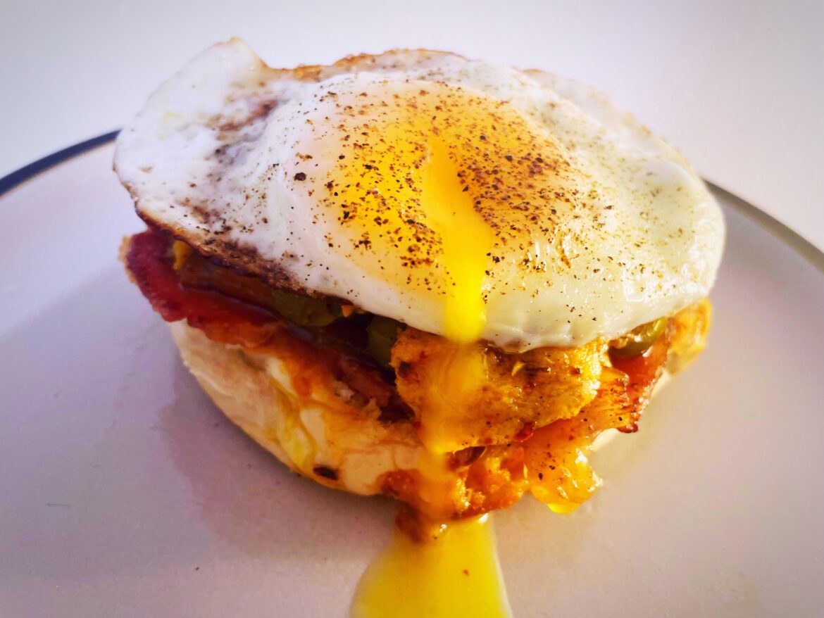 Bacon & egg bap on a peri peri sauce bed with cheese, jalapeños & chilli flakes
