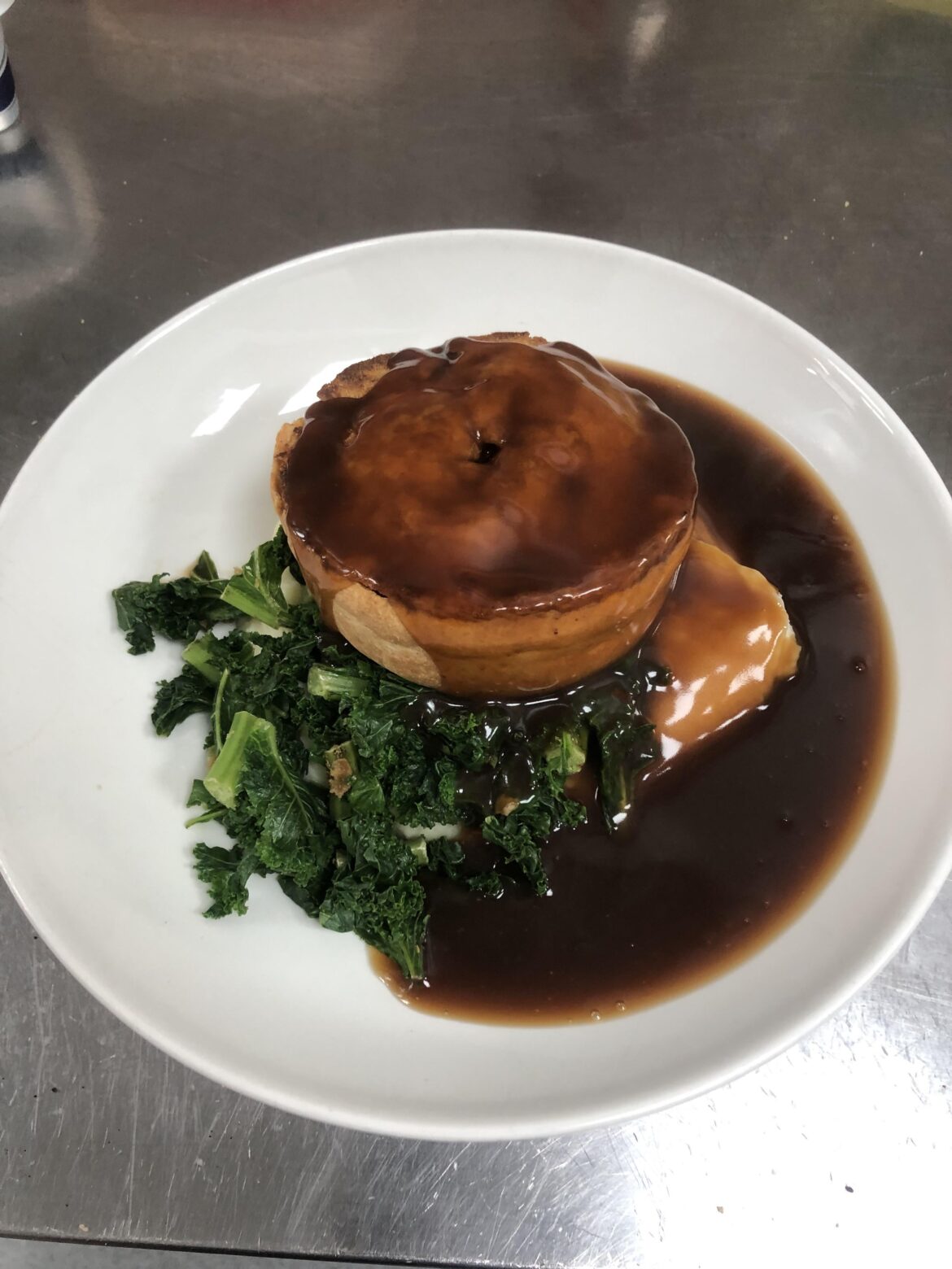 Steak and blue cheese pie with cheddar mash and kale