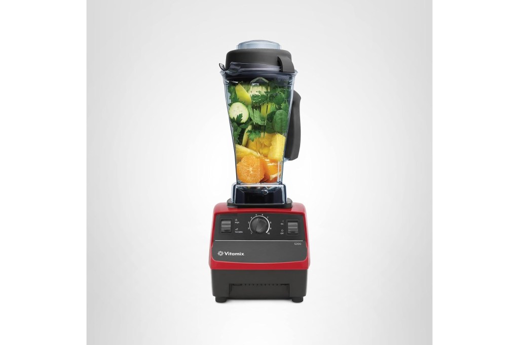 Vitamix 5200 blender with fruits and vegetables inside its container.