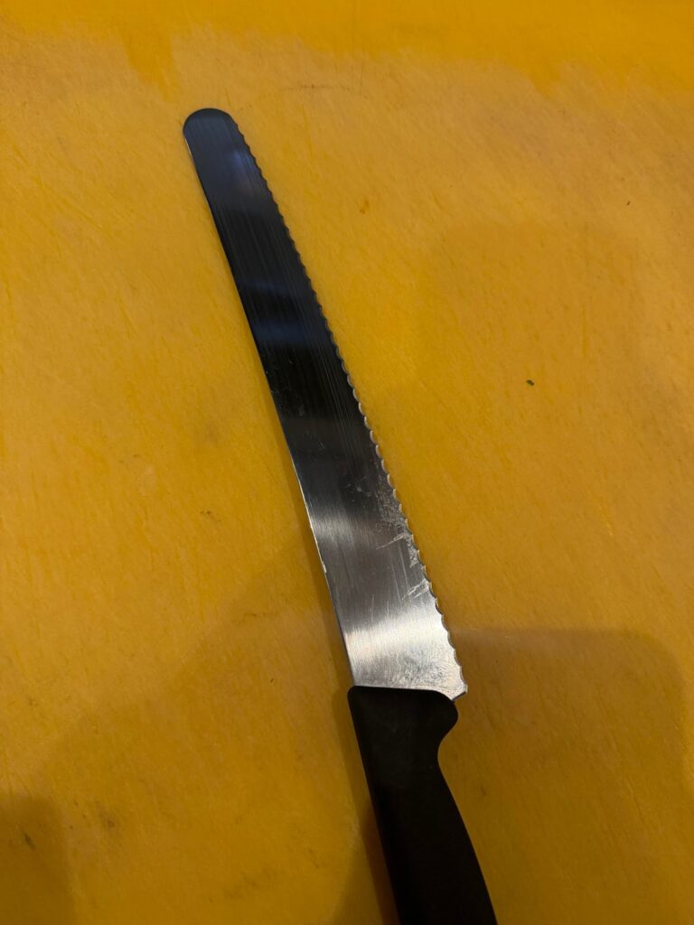 I cut chives with a cake knife on a yellow board