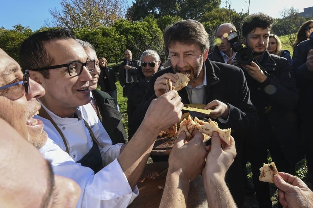 Italian Minister of Culture Dario Franceschini (right) eats a piece of Neapolitan pizza. Photo: Salvatore Laporta/Kontrolab /LightRocket via Getty Images