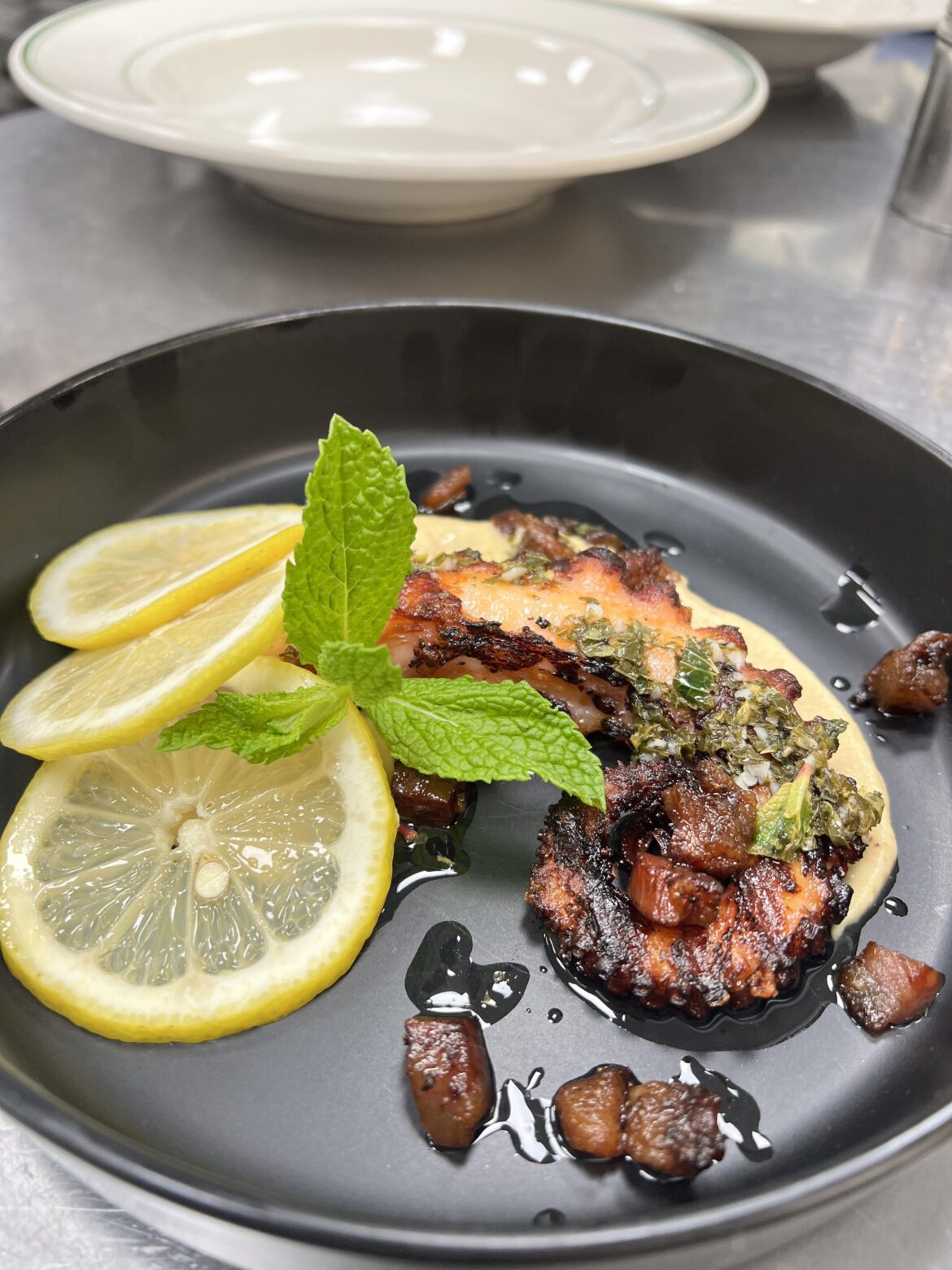 Fried Octopus, Mint Gremolata, Garlic Hummus, Guanciale bits, Lemon Rounds, and Basil
