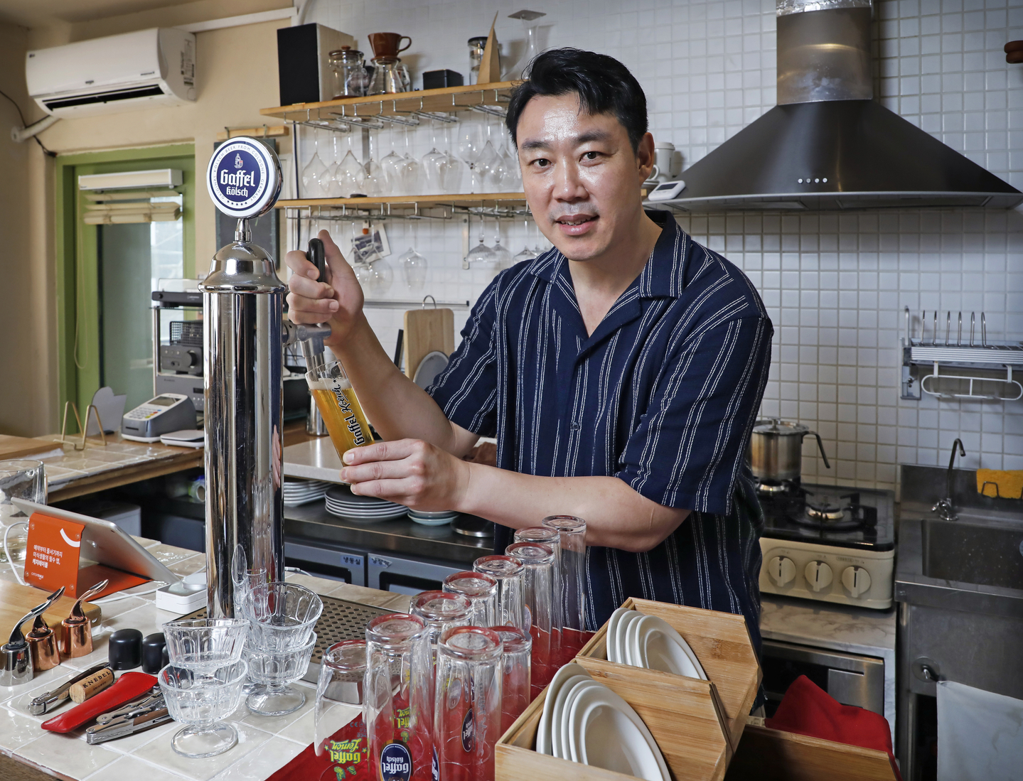 Grund owner Oskar Kim pours beer at the bar. [PARK SANG-MOON]