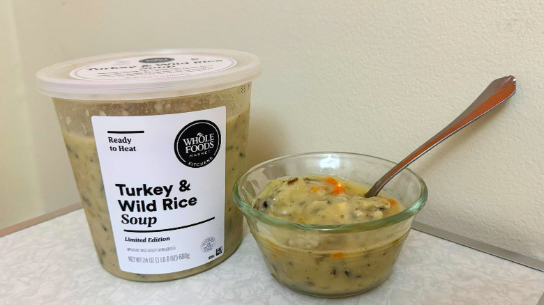A tub and small glass bowl filled with Turkey & Wild Rice Soup