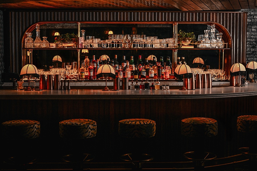 Interior photo of a dimly lit, speakeasy-style bar with Art Deco details.