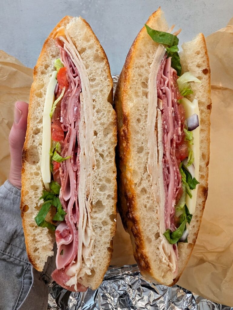 [homemade] Italian sandwich on sourdough focaccia with turkey, genoa salami, mortadella, coppa, lettuce, tomato, onion, provolone, and vinaigrette