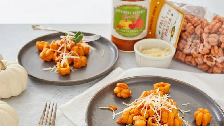 Trader Joe's autumnal harvest creamy pasta sauce on pumpkin-shaped pasta and served on ceramic plates