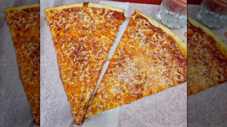 Two slices of cheese pizza on a tray from Amore Pizza in Flushing, Queens