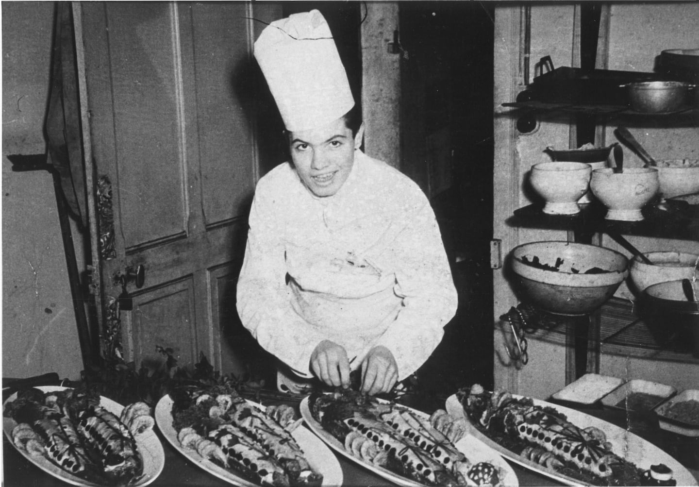 Jacques Pépin, age 16, proudly displays poached fish at the Firemen's Ball of Bellegarde, France, the first banquet he prepared solo.