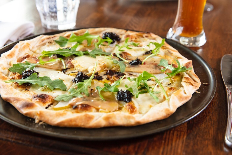 The tarte Parisienne is a flatbread topped with arugula, foie gras, Taleggio cheese, pear slices and red-shallot confiture.