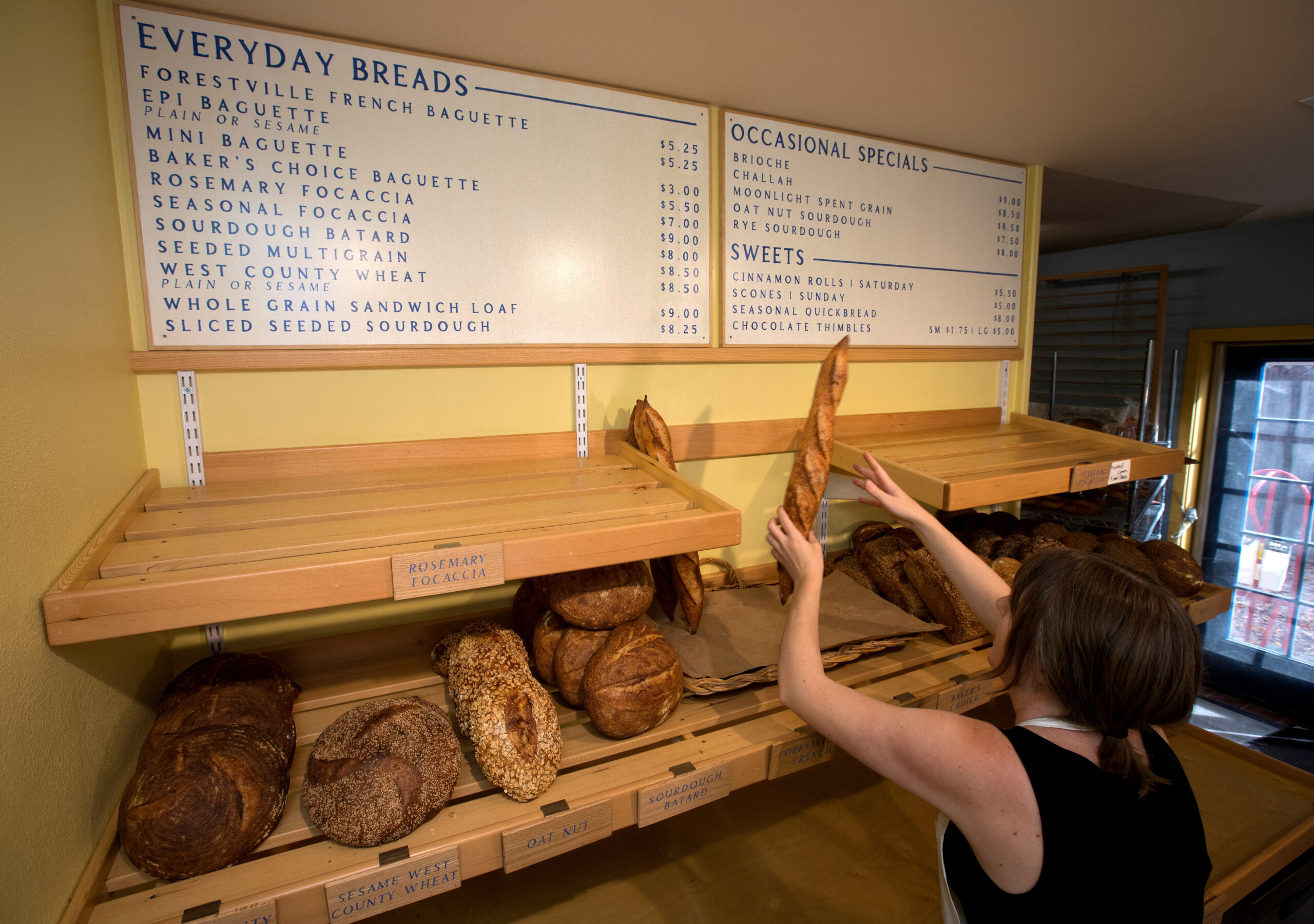 Owner Jessie Frost stacks baguettes for sale at Nightingale Breads, Sunday, October 9, 2022, in Forestville. (Darryl Bush / For The Press Democrat)