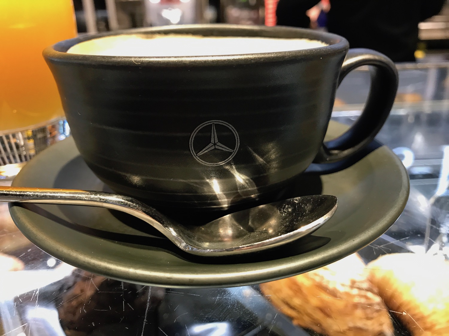 a black cup with a spoon on a saucer