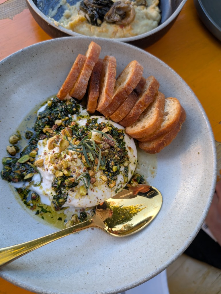 Burrata cheese with dragoncello-pistachio topping (dragoncello is the Italian word for tarragon) and toasted bread at Osteria DOP.