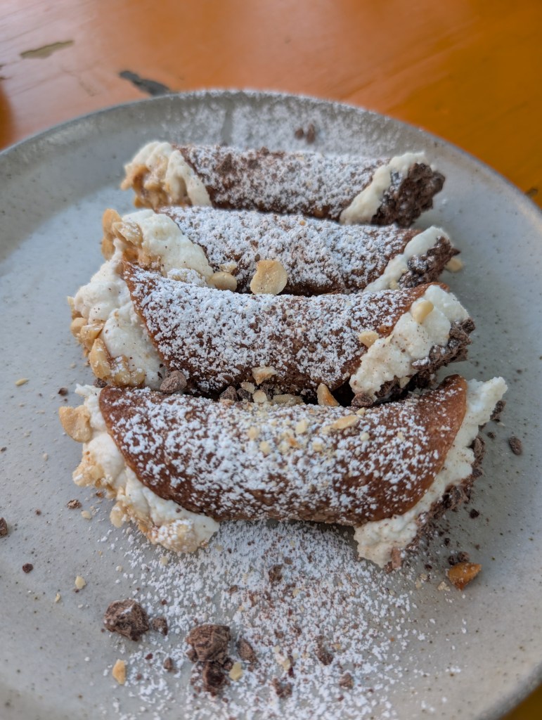 4 cannoli on a plate at Osteria DOP.