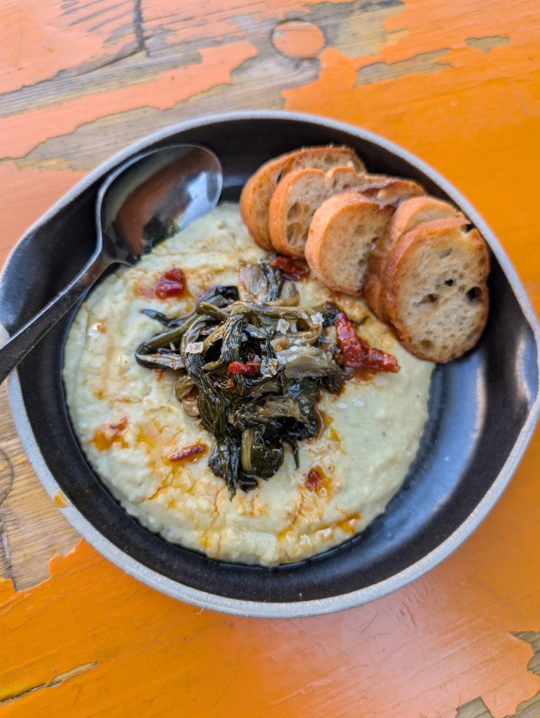 Fava bean puree with sauteed chicory on a plate with toasted bread at Osteria DOP