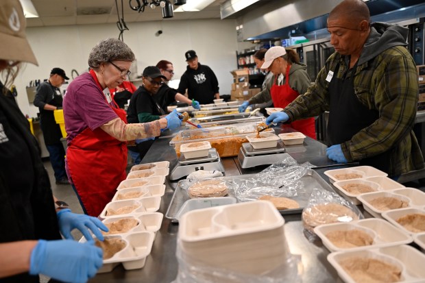 Cook lead Aleyna Jenkins, left, and volunteers Karen Wimberly, second from left, and Troy Quintana, right, help assemble ready-to-eat meals at Food Bank of the Rockies in Denver on Monday, Oct. 6, 2025. (Photo By Patrick Traylor/The Denver Post)