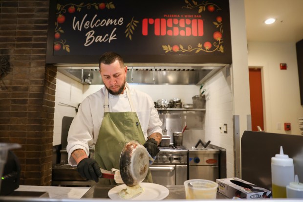Carlos Torres prepares a plate of fried chicken and mashed...