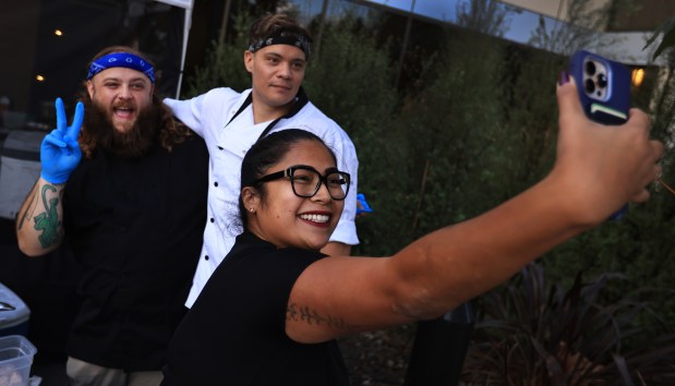 At Old Caz Beer in Rohnert Park, Maria Nixon makes a selfie with chef Bradley Wildridge, left, and chef Cody Candelario, Thursday, Oct. 2, 2025, Wildridge is competing on season 24 of Hell's Kitchen, Candelario competed during season 19. (Kent Porter / The Press Democrat)