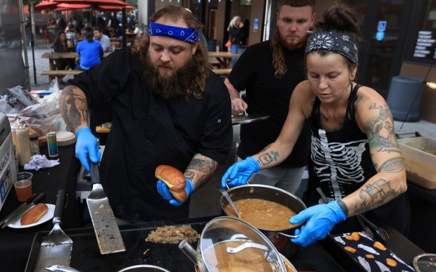 At Old Caz Beer in Rohnert Park chef Bradley Wildridge, left, and wife Mandy with Bayou on the Bay, prepare orders Thursday, Oct. 2, 2025, during a watch party for season 24 of Hell's Kitchen, in which Wildridge is competing in. (Kent Porter / The Press Democrat)